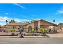 Charming single-story home featuring desert landscaping, covered front porch, and a spacious driveway under a clear blue sky at 635 W Pecos Ave, Mesa, AZ 85210