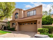 Inviting two-story home featuring a tile roof, well-manicured landscaping, and a spacious two-car garage at 7525 E Gainey Ranch Rd # 110, Scottsdale, AZ 85258