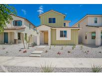Charming two-story home with a vibrant green exterior and well-maintained, low-water landscaping at 15610 S 181St Dr, Goodyear, AZ 85338