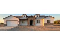 Charming new construction home with a brick archway, attached garage, and desert landscaping at 231Xx W Gloria Ln, Wittmann, AZ 85361