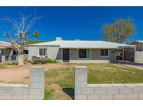 Charming single-story home with a low block wall and a well-manicured lawn at 3422 W Sells Dr, Phoenix, AZ 85017