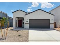 Charming single-story home featuring a red front door, two-car garage, and low-maintenance desert landscaping at 5123 E Umber Rd, San Tan Valley, AZ 85143