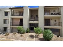Attractive condo building featuring balconies, neutral stucco, and desert landscaping at 5518 E Lindstrom Ln # 1034, Mesa, AZ 85215
