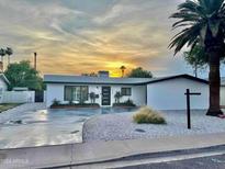 Charming single-story home with modern updates and a well-maintained front yard, set against a beautiful sunset backdrop at 6326 N 86Th N St, Scottsdale, AZ 85250