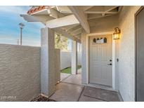Inviting front entry with covered walkway and decorative lighting creates a warm welcome to the residence at 850 S River Dr # 1112, Tempe, AZ 85281
