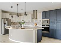 Bright kitchen boasts white cabinets, stainless steel appliances, and a large island perfect for entertaining at 9743 E Torino Ave, Mesa, AZ 85212