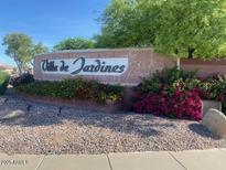 Community entrance sign with colorful flowers, landscaping, and trees at 1306 N Lantana N Pl, Casa Grande, AZ 85122