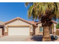 Charming single-story home with a two-car garage and well-maintained landscaping, including a mature palm tree at 16526 W Desert Ln, Surprise, AZ 85388