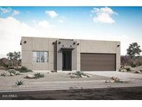 Contemporary one-story home featuring a minimalist desert landscape, a two-car garage, and a modern entrance at 17307 W Via Dona Rd, Surprise, AZ 85387