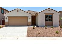 Charming single-story home featuring desert landscaping, a two-car garage, and a covered entryway at 17547 W Lupine Ave, Goodyear, AZ 85338