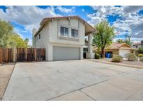 Two-story home with a gray two car garage, concrete driveway, and a red tile roof at 1929 E Redfield Rd, Phoenix, AZ 85022