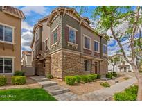 Inviting townhome featuring stacked stone accents, muted green siding, and professional landscaping at 453 N Alder Ct, Gilbert, AZ 85233