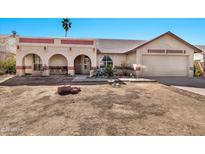 Charming single-story home features a front yard with desert landscaping and attached two-car garage at 4913 E Halifax St, Mesa, AZ 85205