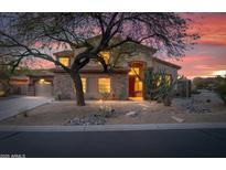 A landscaped front yard with desert rock, stylish stone accents and a spacious driveway enhancing the home's curb appeal at 4958 E Desert Vista Trl, Cave Creek, AZ 85331