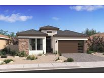 Charming single-story home with a brick accent wall, desert landscaping, and a modern-style garage door at 551 E Aurora Dr, San Tan Valley, AZ 85140