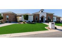 Striking front exterior with stone accents, manicured lawn, and inviting curb appeal at 7482 S Mccormick Way, Queen Creek, AZ 85142