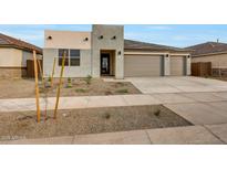 Contemporary home featuring a three car garage and desert landscaping at 14770 W Tether Trl, Surprise, AZ 85387