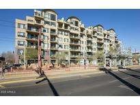 Multi-story condo building featuring balconies, mature landscaping and a city transit stop out front at 2302 N Central Ave # 412, Phoenix, AZ 85004