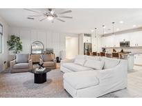 Bright and airy living room featuring a modern ceiling fan, plush seating, and an open layout to the kitchen at 5428 N 188Th Ln, Litchfield Park, AZ 85340