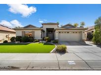 Beautiful single-story home with well-manicured lawn, desert landscaping, and a two-car garage at 5439 N Ormondo Way, Litchfield Park, AZ 85340