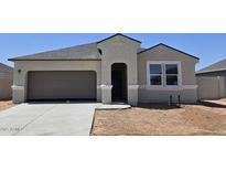 Charming single-story home with a gray exterior, a two-car garage, and a well-manicured lawn at 5735 E Axle Ln, San Tan Valley, AZ 85140