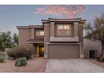 Two-story home showcasing desert landscaping, a tile roof, and a neutral stucco exterior with a two car garage at 7500 E Deer Valley Rd # 157, Scottsdale, AZ 85255