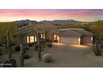 Charming desert home with a three-car garage and a beautiful landscape at sunset at 9776 E Granite Peak Trl, Scottsdale, AZ 85262