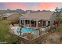 Inviting backyard features a sparkling pool, covered patio, and scenic mountain views, perfect for outdoor entertaining at 11322 N 118Th Way, Scottsdale, AZ 85259