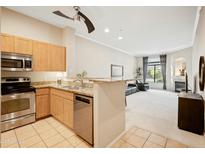 Modern kitchen featuring stainless steel appliances, granite countertops, and a breakfast bar opening to the living area at 11640 N Tatum Blvd # 1052, Phoenix, AZ 85028