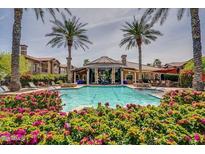 Beautiful community pool and clubhouse surrounded by palm trees and lush landscaping, perfect for relaxation and entertainment at 14250 W Wigwam Blvd # 1022, Litchfield Park, AZ 85340