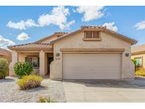 Charming single-story home with a two-car garage, low maintenance yard, and covered entry way at 17125 W Saguaro Ln, Surprise, AZ 85388