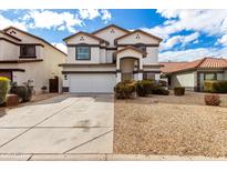 Two-story home featuring a two-car garage, neutral paint, and desert landscaping at 18316 N Soft Wind Dr, Maricopa, AZ 85138