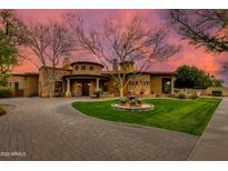 Stunning home with a circular driveway, fountain and mature landscaping, shown at sunset at 2005 N Pomelo --, Mesa, AZ 85215