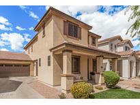 Charming two-story home featuring a covered porch, landscaped yard, and a two-car garage at 2116 S Moccasin Trl, Gilbert, AZ 85295