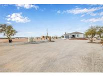 Inviting single-story home featuring a desert landscaped yard and a convenient attached garage, creating a serene outdoor living space at 33608 W Campbell Ave, Tonopah, AZ 85354