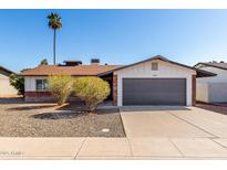 Charming single-story home featuring a gray garage door and desert landscaping for low maintenance at 1215 W Dublin St, Chandler, AZ 85224