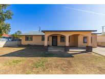 Inviting single-story home featuring a covered porch and a well-maintained front yard under a clear blue sky at 1427 W 6Th Dr, Mesa, AZ 85202