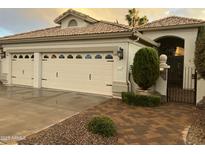 Charming home featuring a three car garage, tile roof, and decorative wrought iron gate and walkway at 16167 W Monterey Way, Goodyear, AZ 85395