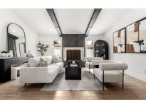 Bright living room with fireplace, neutral furniture, black beams, and wood floors at 1971 E Sunburst Ln, Tempe, AZ 85284