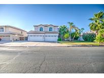 Charming two-story home featuring a three-car garage, mature trees, and desert landscaping at 2072 E Sierra Madre Ave, Gilbert, AZ 85296