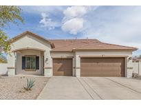 Charming single-story home featuring a two-car garage, desert landscaping, and a covered porch entry at 4116 W Milada Dr, Laveen, AZ 85339