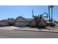 Inviting single-story home featuring a two-car garage and xeriscaped front yard with desert landscaping at 415 W Mohawk Ln, Phoenix, AZ 85027