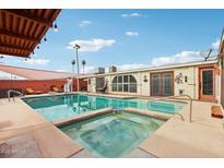 Beautiful pool with hot tub, statue, and covered patio perfect for entertaining on a sunny day at 6217 W Orange Dr, Glendale, AZ 85301