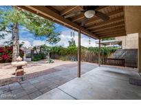 Covered patio showcases a ceiling fan, and a view to the backyard with mature trees at 730 E Rosemonte Dr, Phoenix, AZ 85024