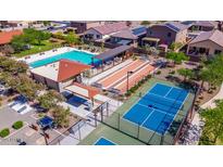 Aerial view showcasing community amenities: pool, tennis courts, bocce ball, ramada, and lush landscaping at 18227 W Daley Ln, Surprise, AZ 85387