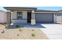 Charming single-story home with a two-car garage, low-maintenance landscaping, and stone accents at 18243 W Daley Ln, Surprise, AZ 85387