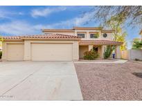 Charming two-story home with a red tile roof, three-car garage, and desert landscaping at 4831 N 93Rd Dr, Phoenix, AZ 85037