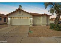 Charming single-Gathering home featuring a two-car garage and low maintenance desert landscaping at 7056 W Caron Dr, Peoria, AZ 85345