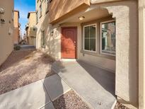 Inviting front entrance with a vibrant orange door and well-maintained landscaping at 7720 W Pipestone Pl, Phoenix, AZ 85035