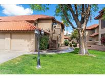 Charming condo featuring a lush green lawn and classic Southwest architecture with a red tile roof at 8700 E Mountain View Rd # 2058, Scottsdale, AZ 85258